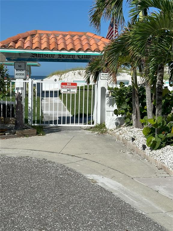 A gated entrance with a tiled roof leads to a private beach access path — 181st AVE W, REDINGTON SHORES, FL
