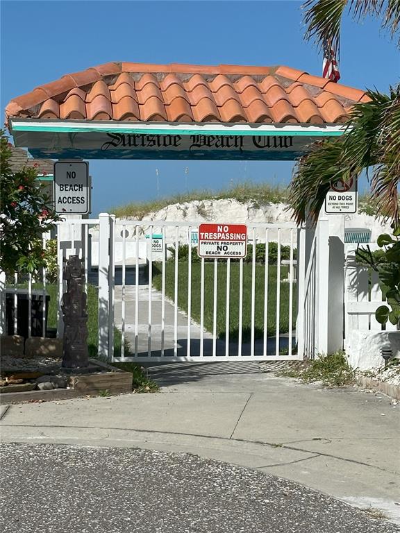 A gated entrance to the Surfside Beach Club features a tiled roof and signage — 181st AVE W, REDINGTON SHORES, FL