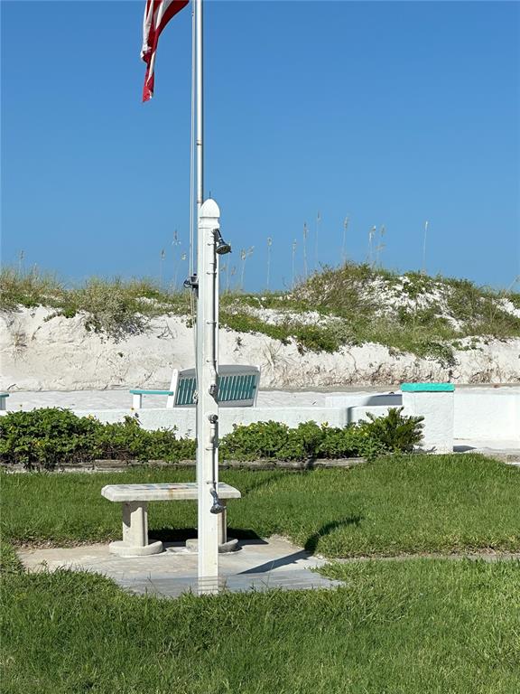 An outdoor shower stands on a concrete pad in a grassy area near sand dunes — 181st AVE W, REDINGTON SHORES, FL