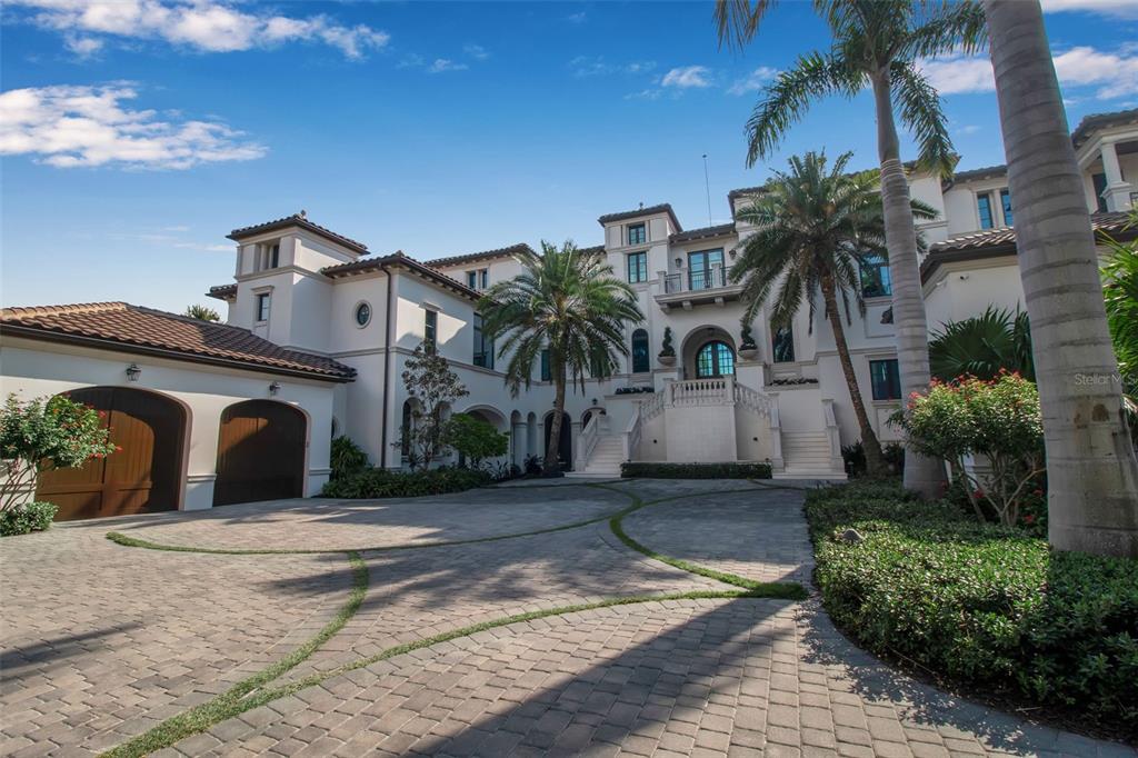 A large Mediterranean-style mansion features a paved circular driveway, palm trees, and a grand staircase — 7366 POINT OF ROCKS ROAD, SARASOTA, FL