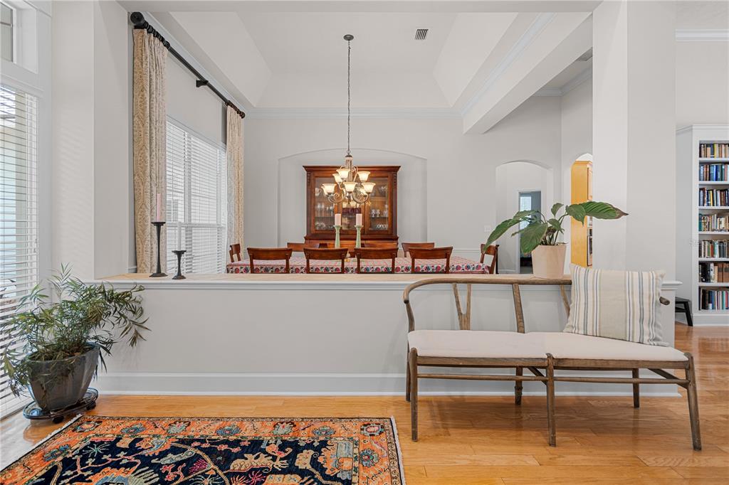 A dining room is visible behind a half wall with a bench in the foreground — 3212 SW 98TH DRIVE, GAINESVILLE, FL