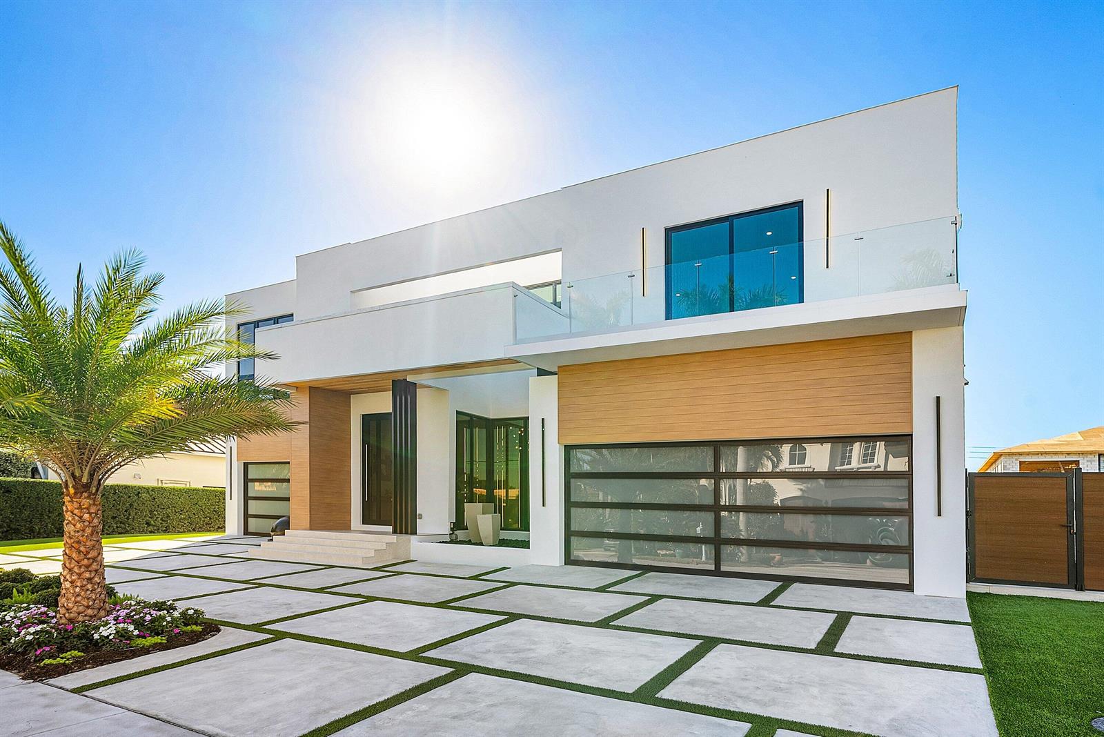 A modern two-story house with a white facade, wood accents, and a paved driveway — 750 NE 69th Street, Boca Raton FL 33487, BOCA RATON, FL