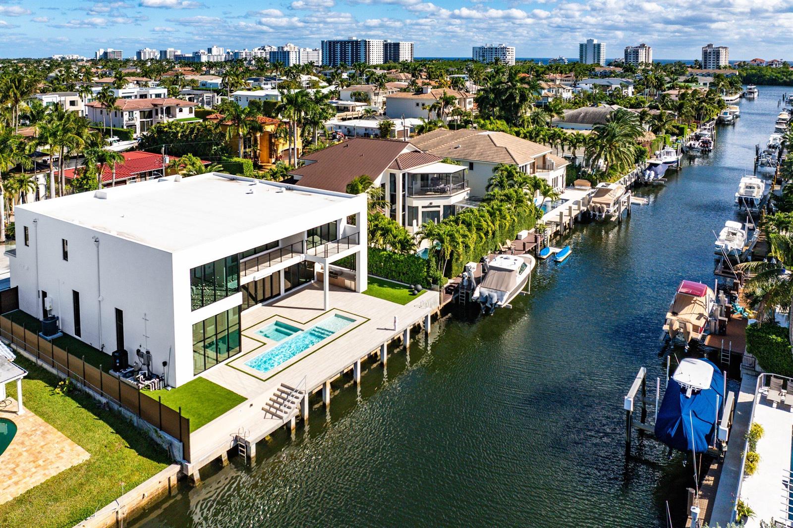 An aerial view of a modern white waterfront home with a pool and private dock — 750 NE 69th Street, Boca Raton FL 33487, BOCA RATON, FL