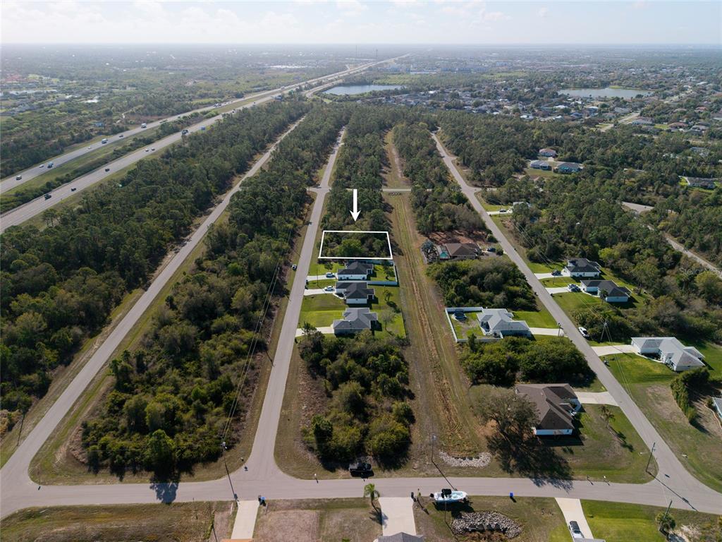 An aerial view shows a vacant, wooded residential lot marked by a white outline — Lot 6 SAWYER CIRCLE, NORTH PORT, FL