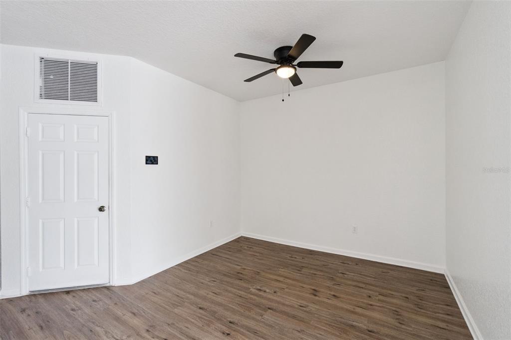 A room with white walls, wood-look flooring, and a ceiling fan — 3491 ALLEGRA CIRCLE, ST CLOUD, FL