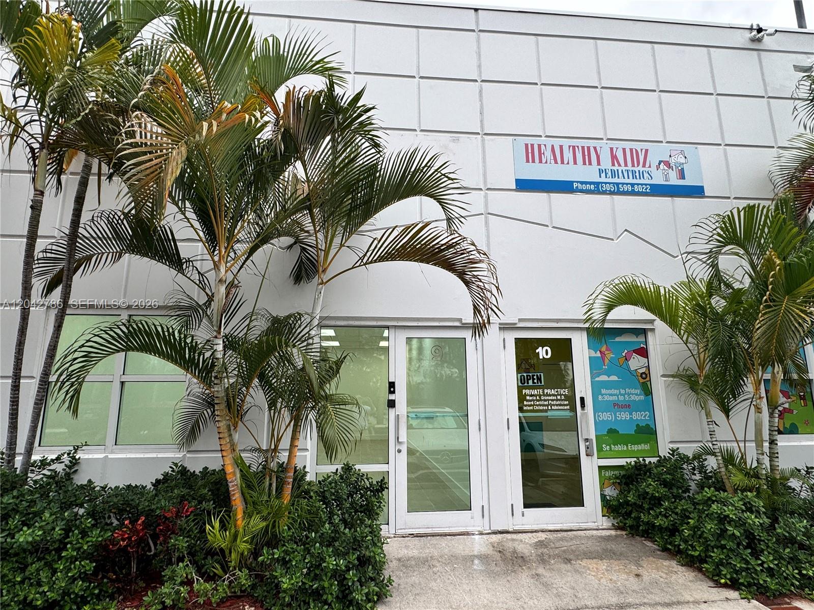 The exterior of a pediatric office building features palm trees, glass doors, and signage — 4005 NW 114th Ave # 09, Doral FL 33178, DORAL, FL