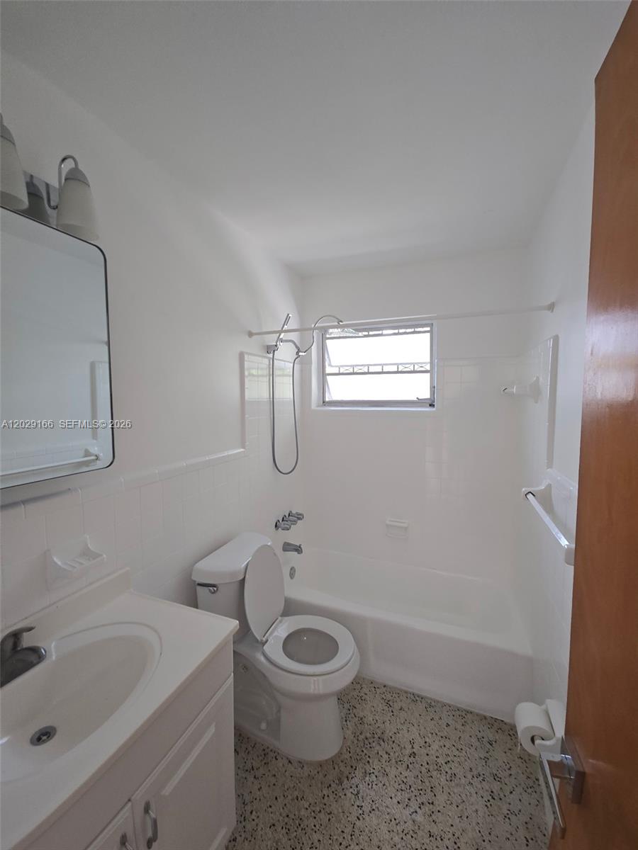This bathroom features a white vanity, a toilet, and a shower-tub combination with white tile — 3435 NW 4th St, Miami FL 33125, MIAMI, FL