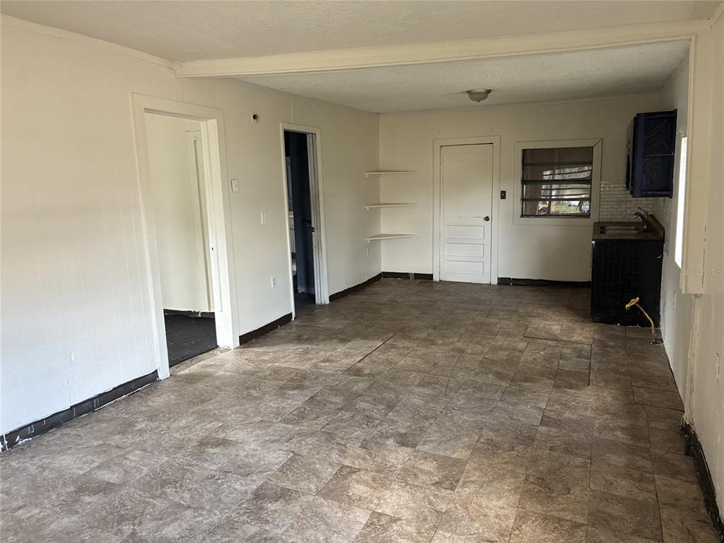An interior view of a room with white walls, tile flooring, and a small kitchenette — 10529 3RD AVENUE, OCOEE, FL
