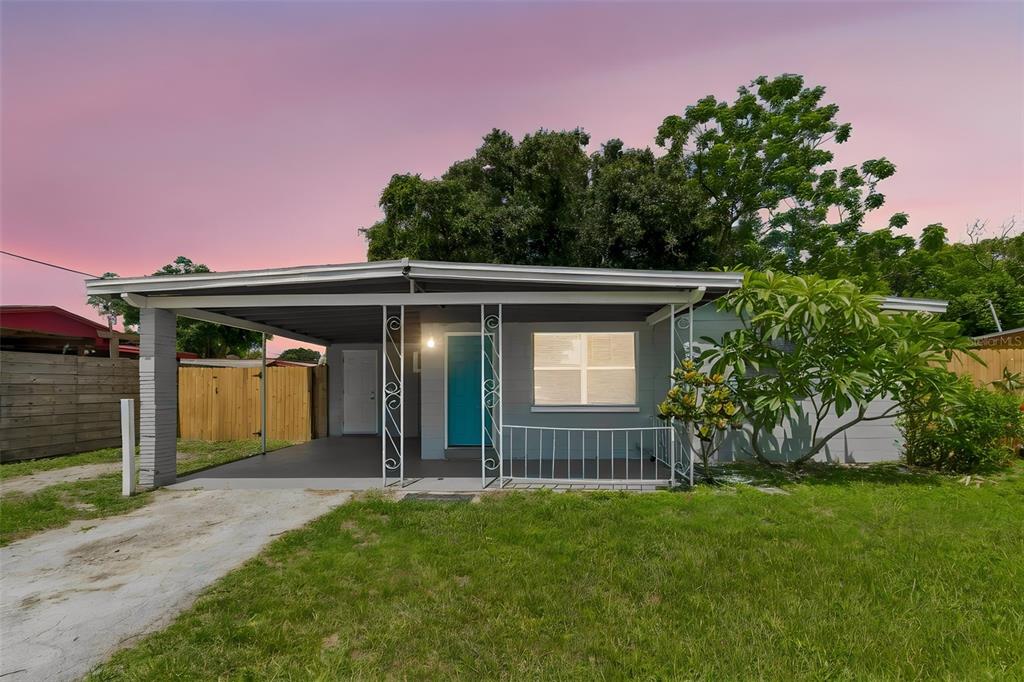 A single-story house with a gray exterior, a carport, and a bright blue front door — 11136 104TH STREET, LARGO, FL