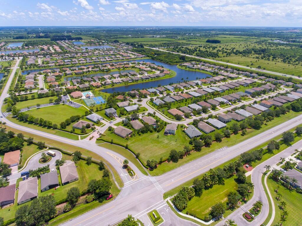 An aerial view shows a suburban neighborhood with houses, lakes, and a community pool — 521 N Valencia Circle SW, Vero Beach FL 32968, VERO BEACH, FL