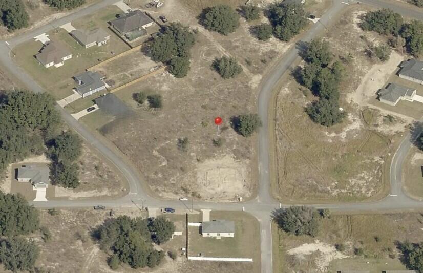 An aerial view shows a vacant, grassy residential lot marked with a red pin — 0 Locust Loop Lane, Ocala FL 34472, OCALA, FL