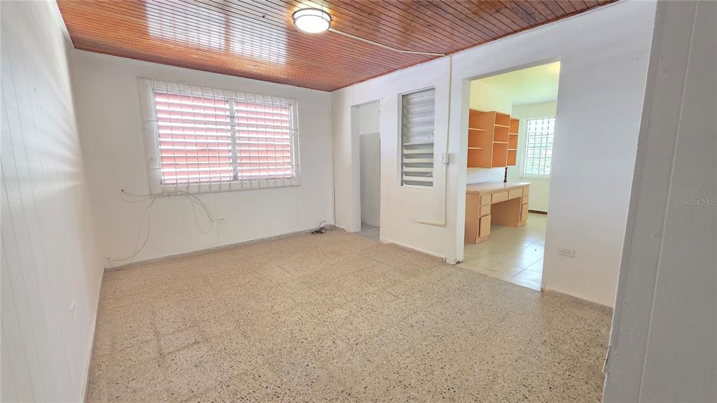 A room with a wood-paneled ceiling, terrazzo flooring, and a doorway leading to a kitchen — PR 922 KM 0.4 BO. COLLORES, LAS PIEDRAS, PR
