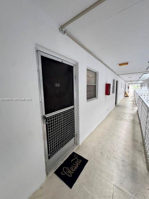 An exterior hallway features a door with a screen, a welcome mat, and a railing — 6505 Winfield Blvd # 51, Margate FL 33063, MARGATE, FL