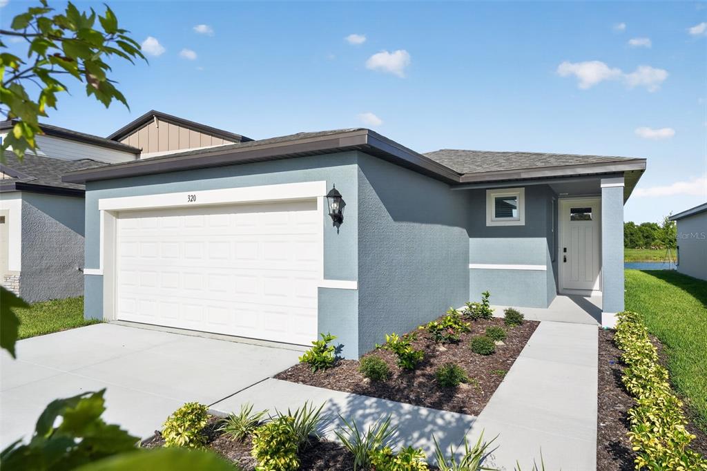 A single-story house with a blue stucco exterior, a white garage door, and a walkway — 320 LAZY SHORE DRIVE, NOKOMIS, FL