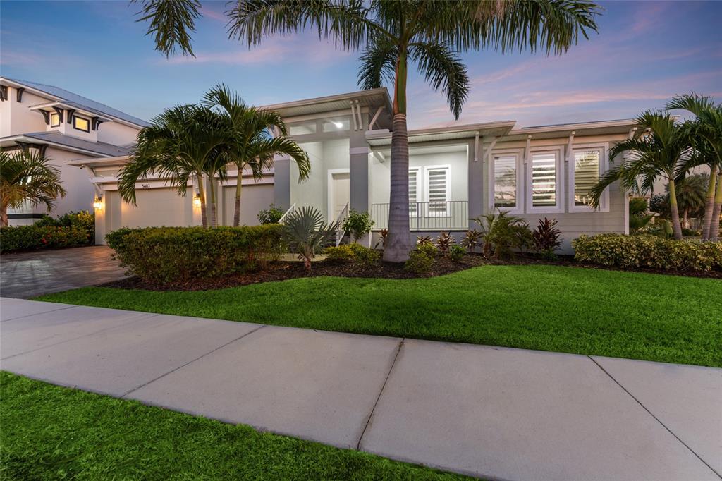 A single-story house with a palm tree in the front yard and a paved driveway — 5603 TYBEE ISLAND DRIVE, APOLLO BEACH, FL