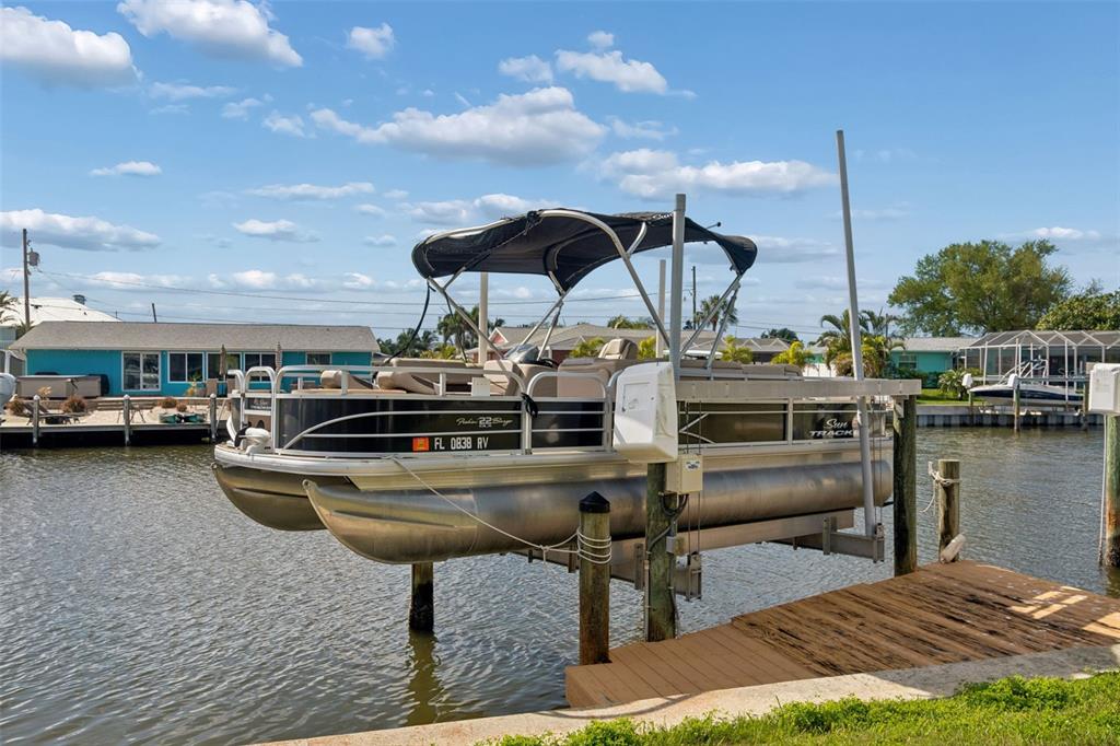 An aerial view shows several boats docked along a canal beside waterfront houses — 10443 WATERBIRD WAY, BRADENTON, FL