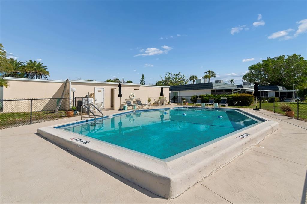 An outdoor rectangular swimming pool is surrounded by a concrete deck and a chain-link fence — 10443 WATERBIRD WAY, BRADENTON, FL