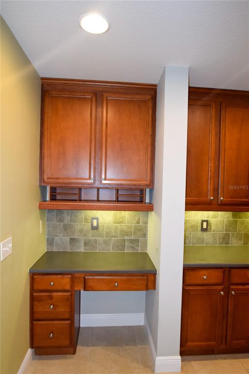 A kitchen desk area features wood cabinets, a gray countertop, and a tiled backsplash — 1420 LAKE BALDWIN LANE, ORLANDO, FL
