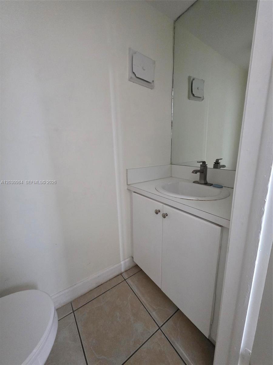 A small bathroom features a white vanity with a sink, a mirror, and tiled flooring — 8550 SW 109th Ave # 228, Miami FL 33173, MIAMI, FL