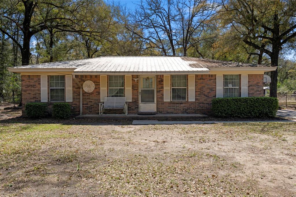 A single-story brick house with a metal roof and white shutters sits on a lot — 1788 HIGHWAY 10A, PONCE DE LEON, FL