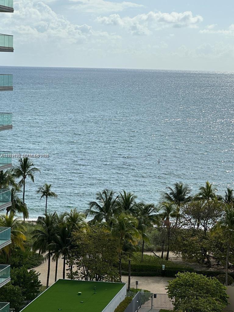 A high-angle view of the ocean, beach, and palm trees from a balcony — 10185 Collins Ave # 1103, Bal Harbour FL 33154, BAL HARBOUR, FL