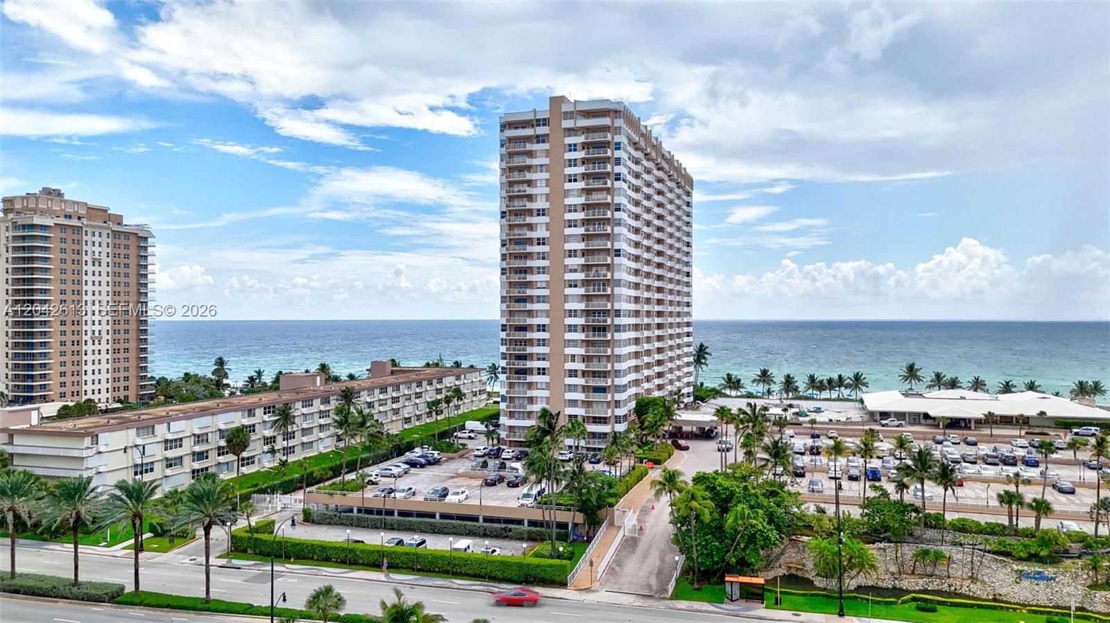 An aerial view shows two large residential buildings near the ocean with parking lots — 1950 S Ocean DR. # 6B, Hallandale Beach FL 33009, HALLANDALE BEACH, FL