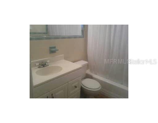 A bathroom features a white vanity with a sink, a toilet, and a shower-tub combination — 2711 LYNNHURST STREET, SARASOTA, FL