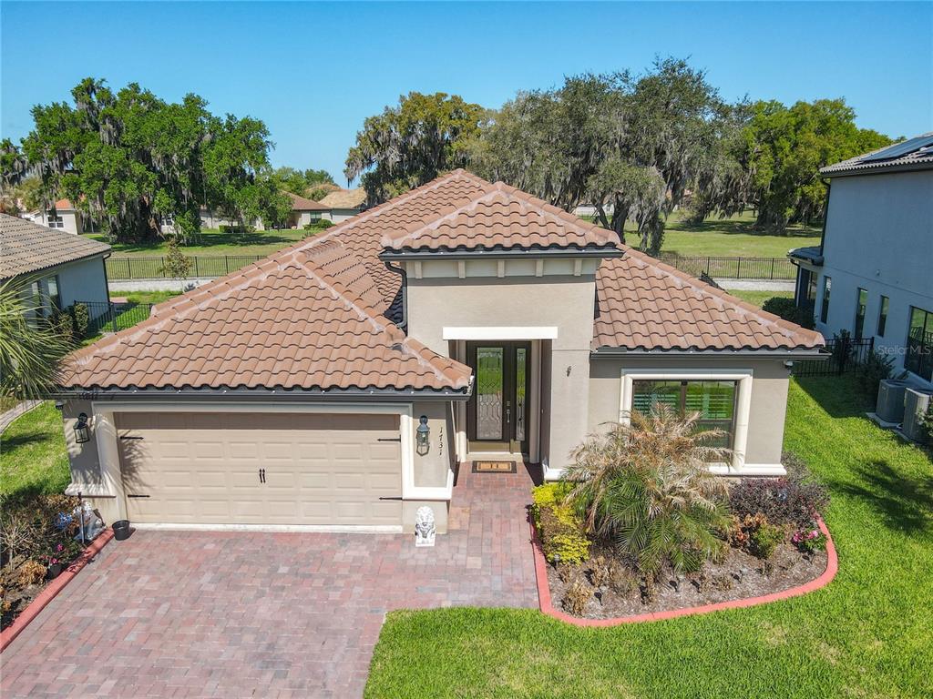 An aerial view of a single-story house with a tile roof and a paved driveway — 1731 GOBLET COVE STREET, KISSIMMEE, FL