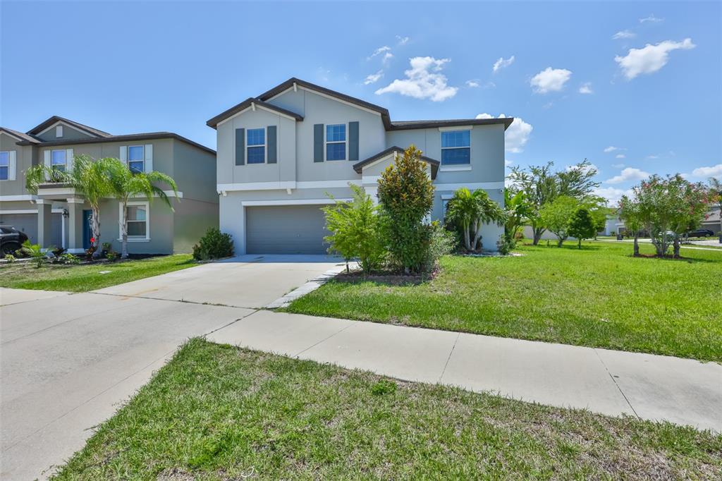 A two-story suburban house with a gray exterior, a two-car garage, and a front lawn — 11503 SAGE CANYON DRIVE, RIVERVIEW, FL