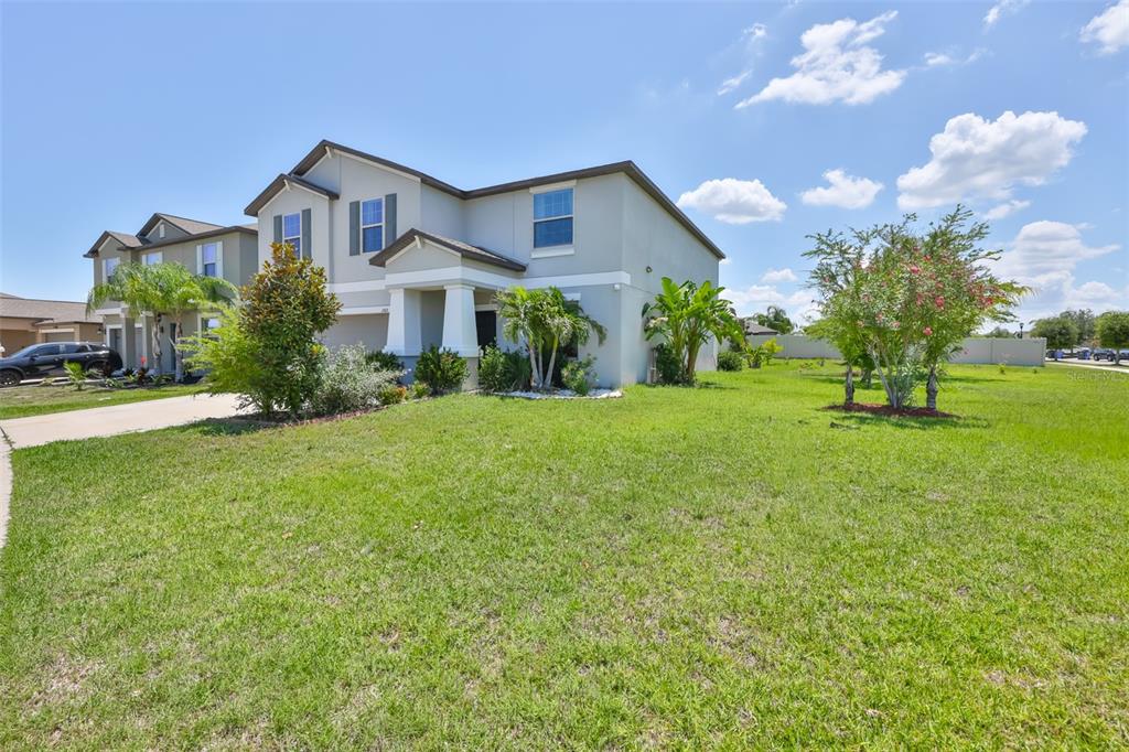A two-story suburban house with a light-colored exterior, a front porch, and a grassy yard — 11503 SAGE CANYON DRIVE, RIVERVIEW, FL