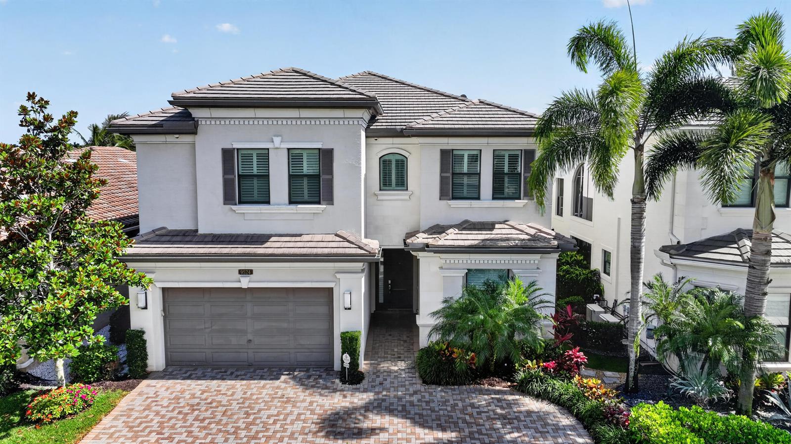 A two-story house with a gray tile roof, stucco exterior, and a paved driveway — 9524 Eden Roc Court, Delray Beach FL 33446, DELRAY BEACH, FL