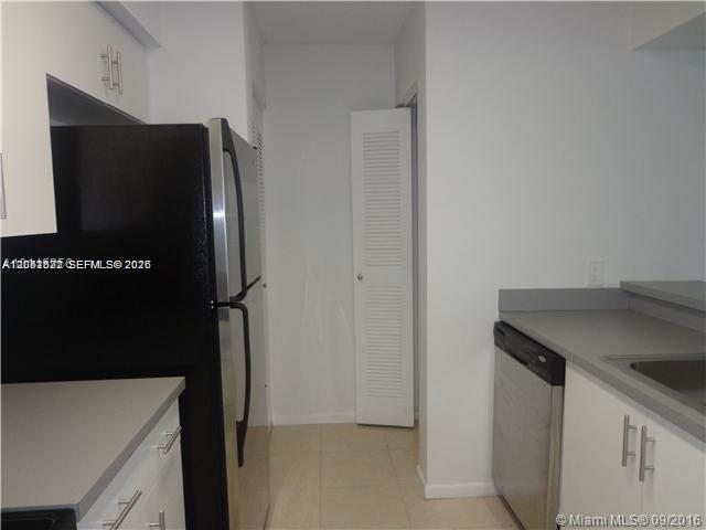 A kitchen features white cabinets, stainless steel appliances, and a louvered door — 540 S Park Road # 9, Hollywood FL 33021, HOLLYWOOD, FL