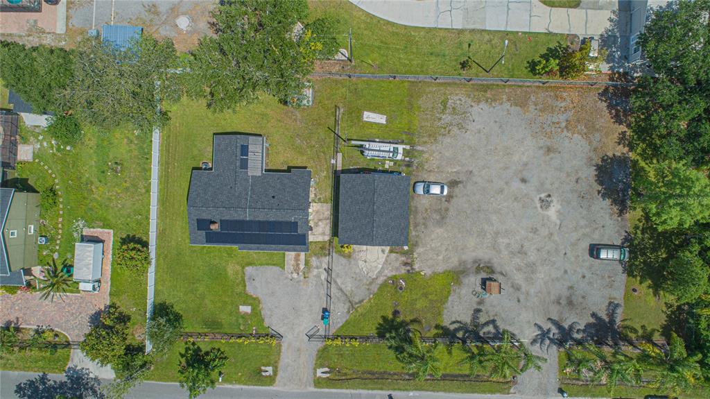 An aerial view shows a house with solar panels, a detached garage, and a large lot — 6105 NEW HOPE ROAD, ORLANDO, FL