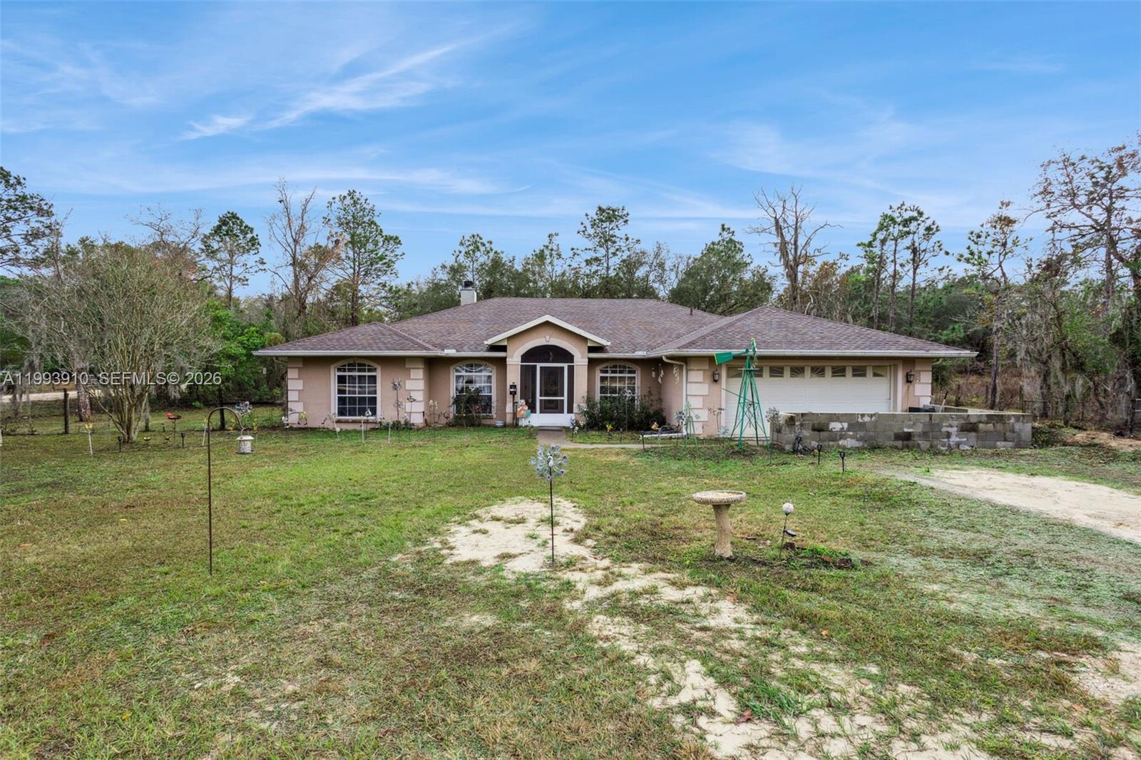 A single-story house with a beige exterior, a two-car garage, and a large front yard — 14170 SE 4th St., Williston FL 32696, WILLISTON, FL