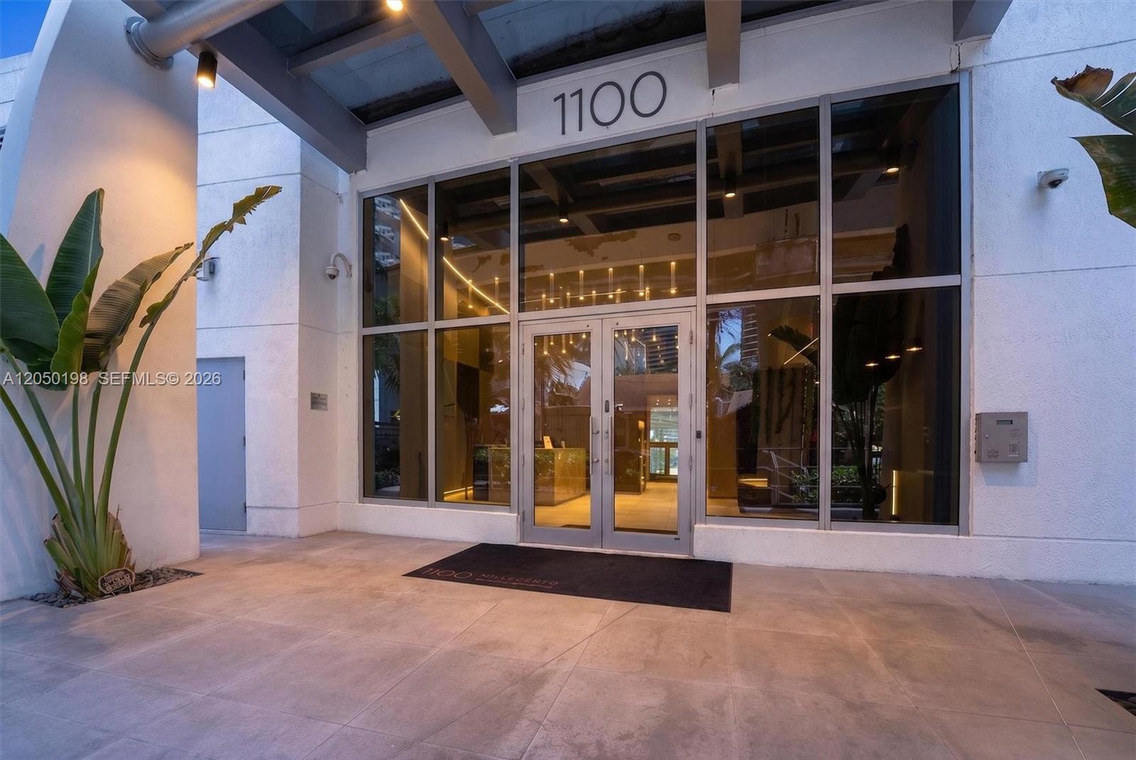 The exterior entrance of a building features glass doors, large windows, and a concrete walkway — 1100 S Miami Ave # 3707, Miami FL 33130, MIAMI, FL