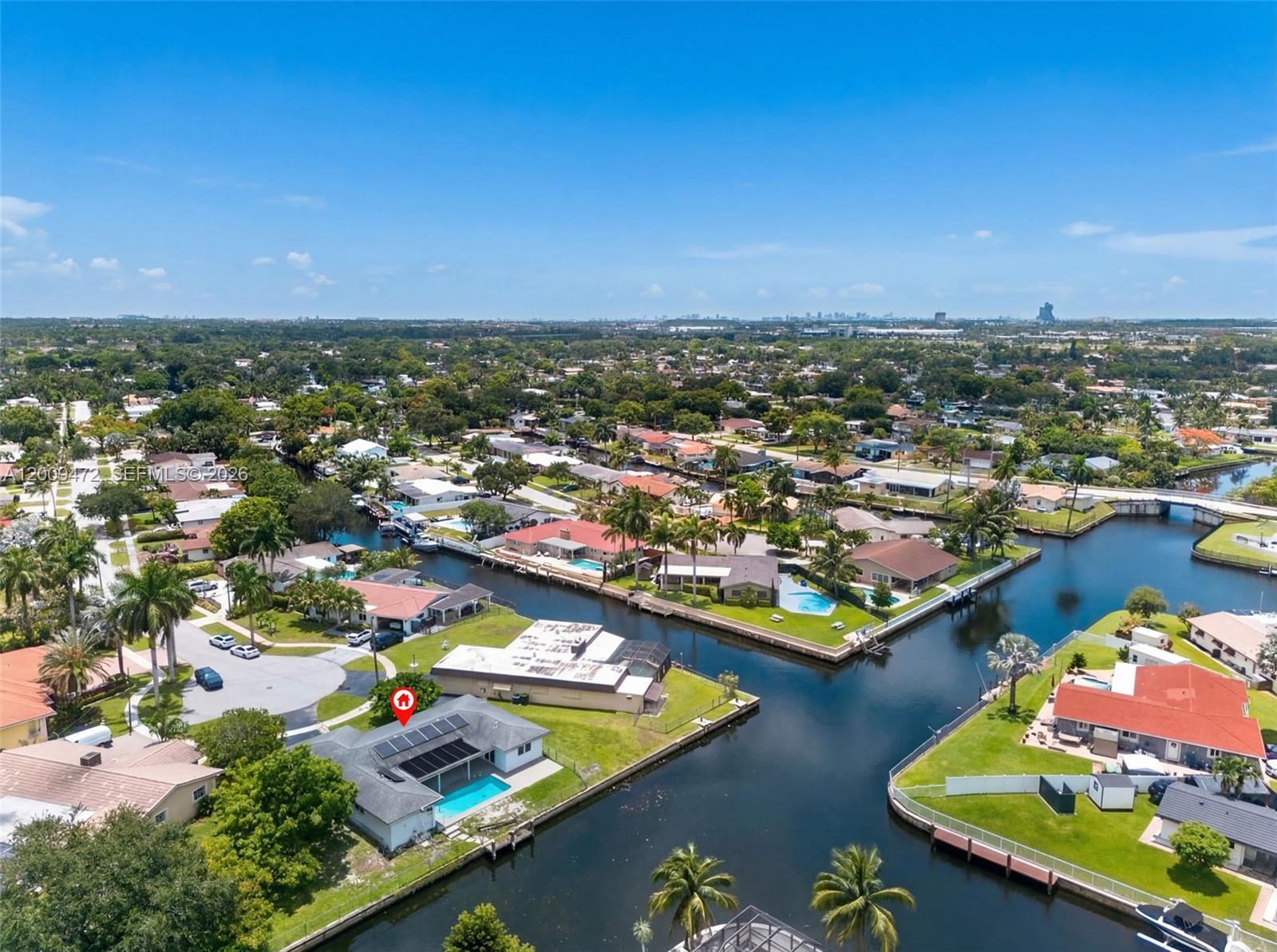 An aerial view shows a waterfront house with a swimming pool and solar panels — 6091 SW 14th St, Plantation FL 33317, PLANTATION, FL