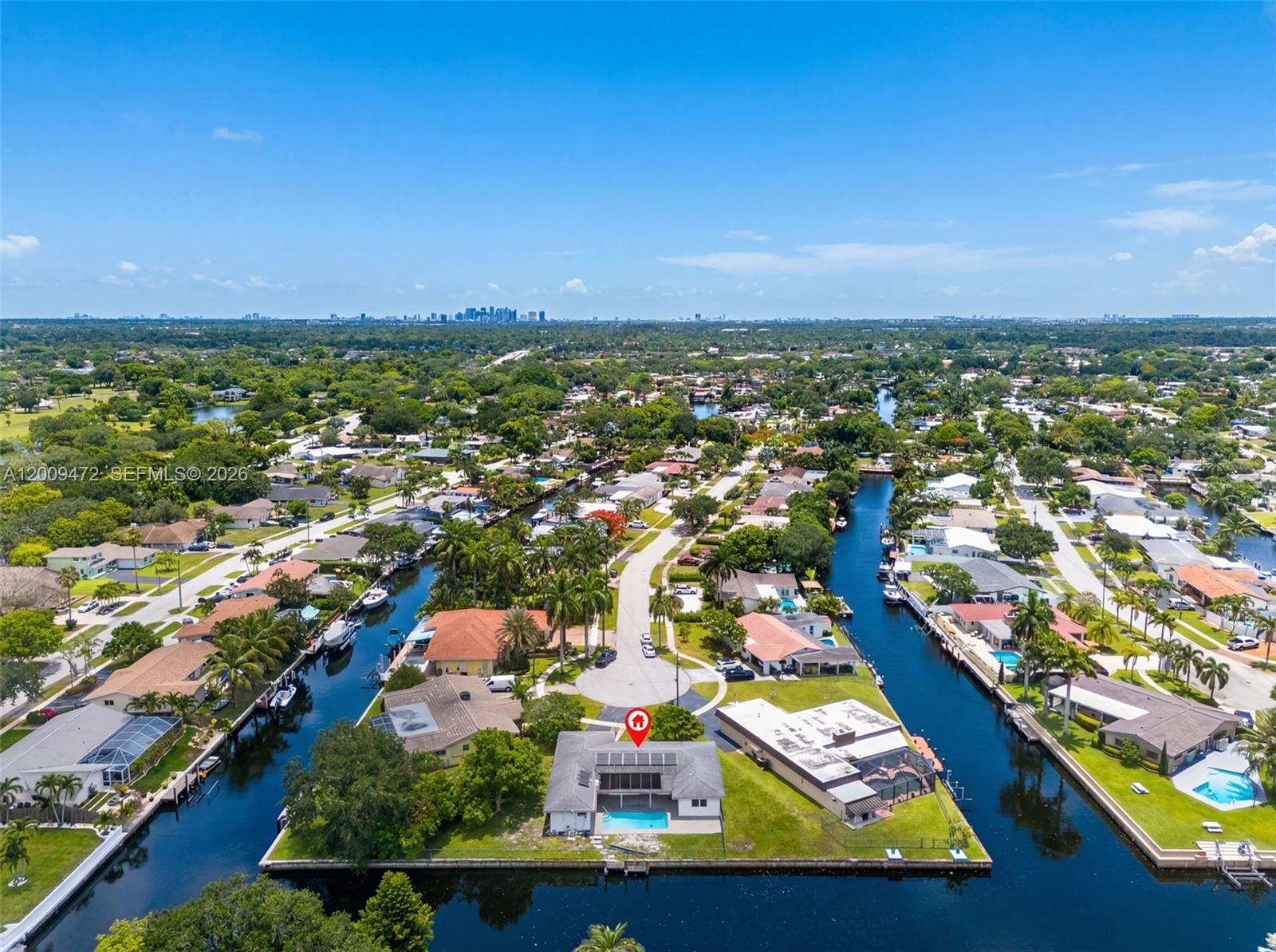 An aerial view shows a waterfront house with a pool located on a canal point — 6091 SW 14th St, Plantation FL 33317, PLANTATION, FL