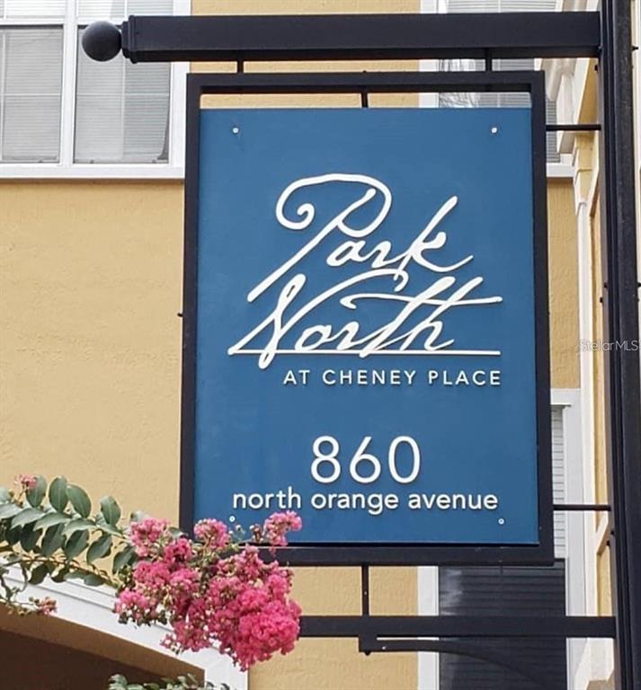 A blue sign with white text identifies the building as Park North at Cheney Place — 860 N ORANGE AVENUE UNIT 145, ORLANDO, FL