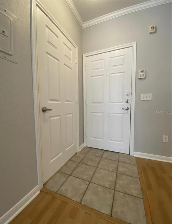 An entryway features a white front door, a closet door, tile flooring, and light gray walls — 860 N ORANGE AVENUE UNIT 145, ORLANDO, FL