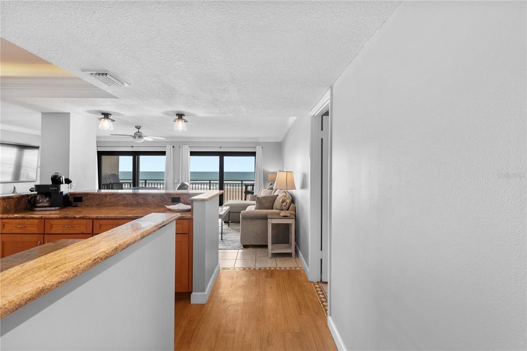 A view from a hallway looking into a kitchen and living area with ocean views — 4445 S ATLANTIC AVENUE UNIT 202, PONCE INLET, FL