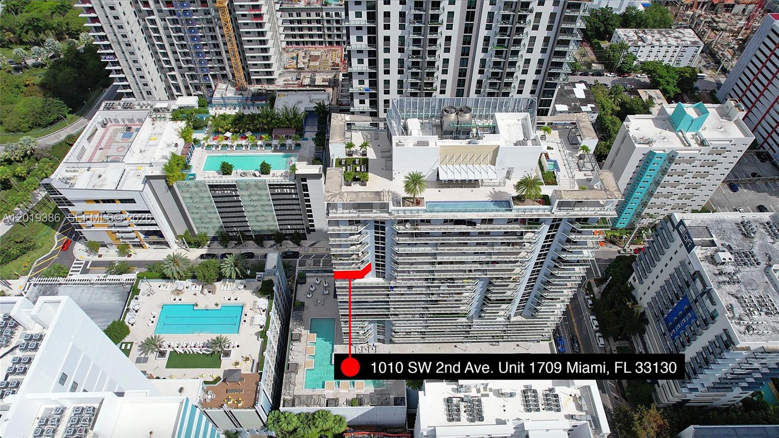 An aerial view shows a high-rise apartment building with a red arrow pointing to a unit — 1010 SW 2nd Ave # 1709, Miami FL 33130, MIAMI, FL