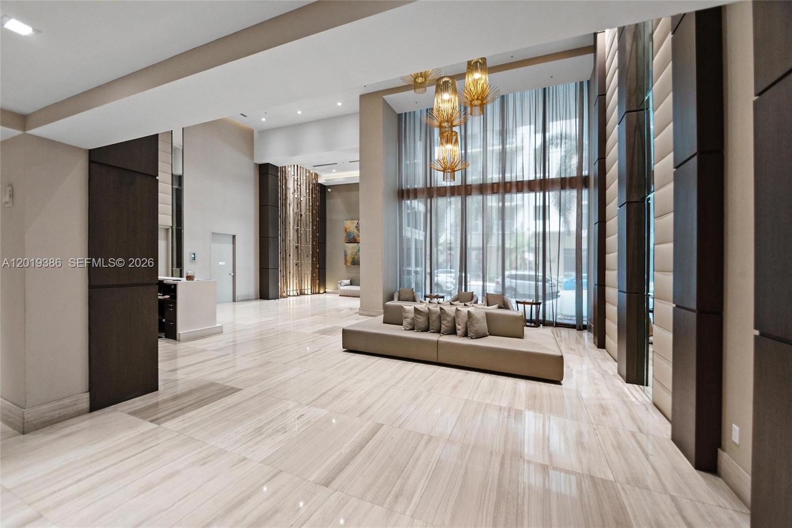 A modern lobby features marble floors, high ceilings, floor-to-ceiling windows, and a central sofa — 1010 SW 2nd Ave # 1709, Miami FL 33130, MIAMI, FL
