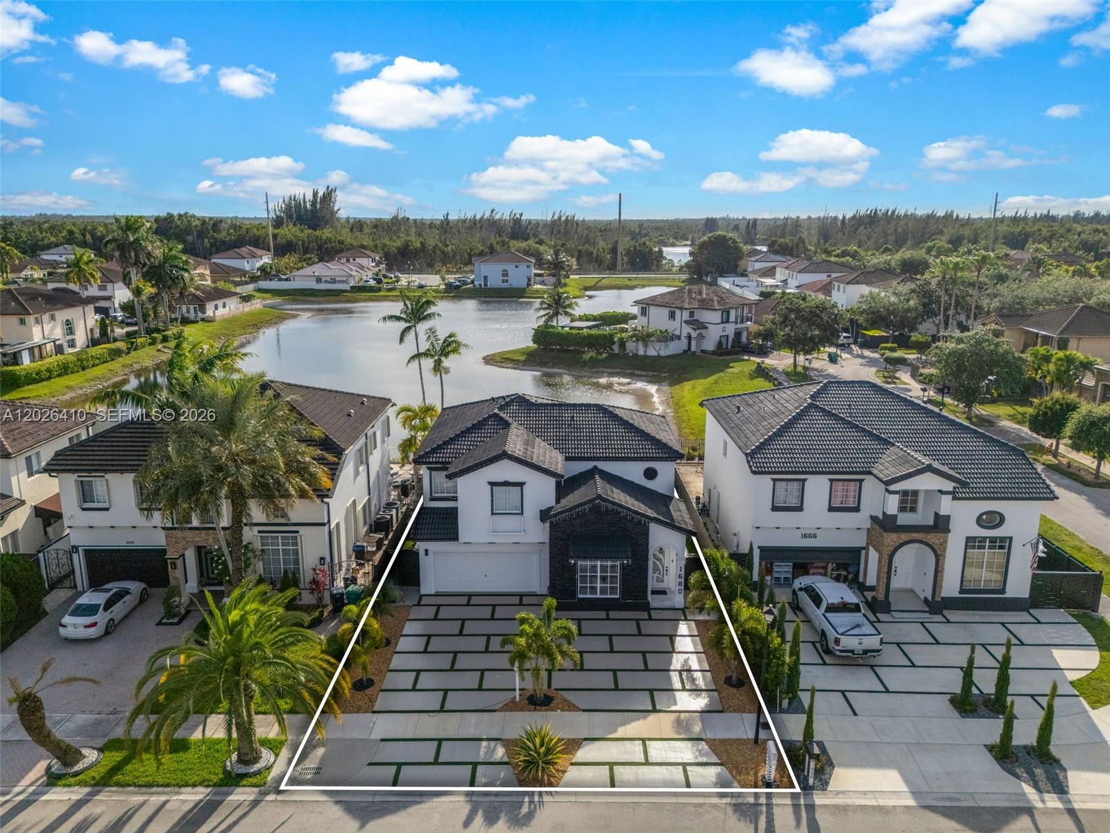 An aerial view of a two-story house with a paved driveway and a lake behind — 1680 SW 154th Path, Miami FL 33185, MIAMI, FL