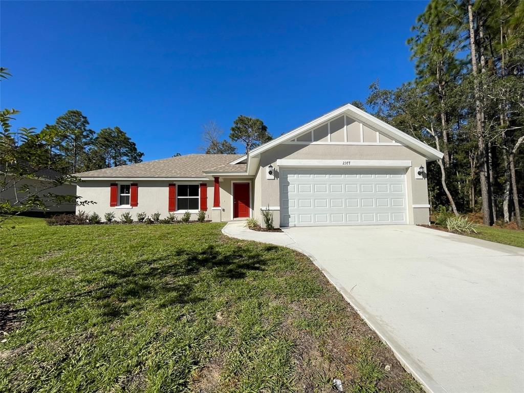 A single-story house with a beige exterior, red shutters, and a two-car garage — 2377 W MENORES DRIVE, CITRUS SPRINGS, FL