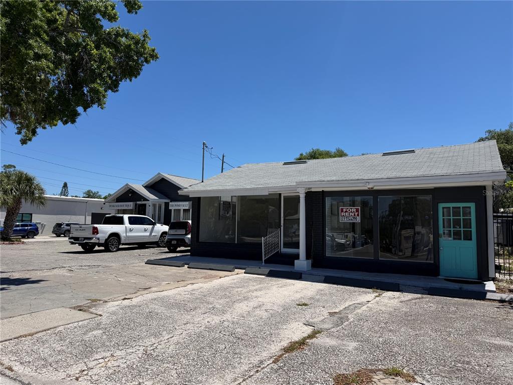 A commercial building with a gray roof, black exterior, and a teal door for rent — 1771 CLEARWATER LARGO ROAD, CLEARWATER, FL
