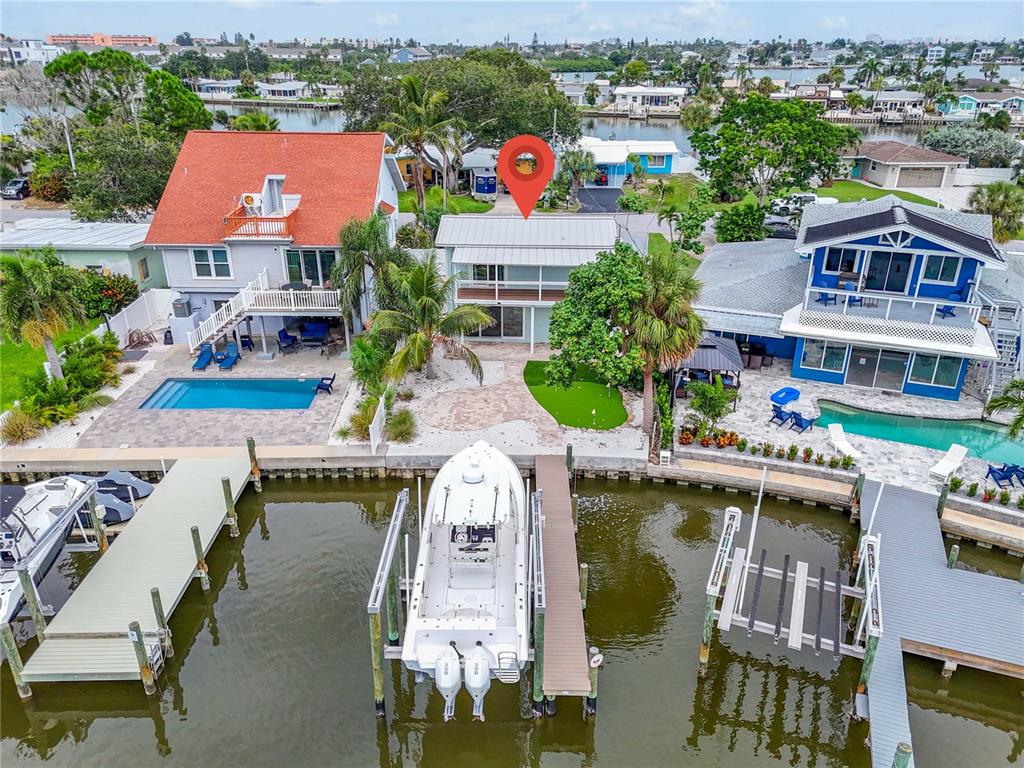 An aerial view shows a waterfront house with a boat lift and a putting green — 349 BAHIA VISTA DRIVE, INDIAN ROCKS BEACH, FL