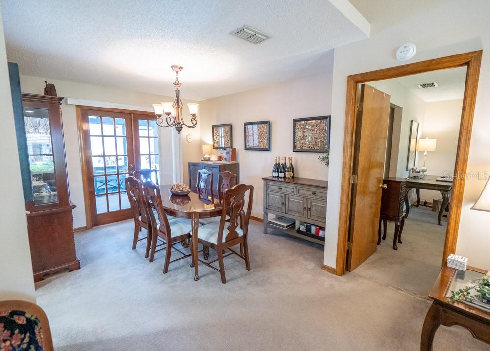 A dining room with a wooden table, chairs, a sideboard, and a glass-paned door — 7213 REGENT DRIVE, LAKELAND, FL