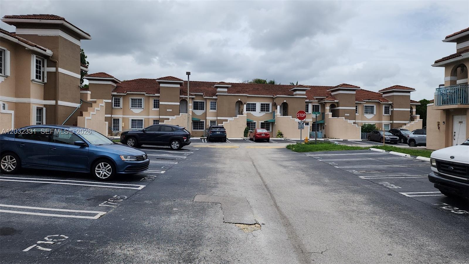 An exterior view of a multi-story apartment complex with a parking lot in the foreground — 6416 SW 131st Path # 1705, Miami FL 33183, MIAMI, FL