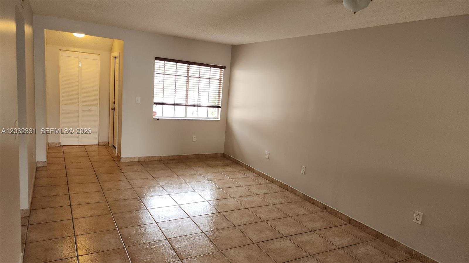 An empty room features beige tile flooring, light-colored walls, and a window with blinds — 6416 SW 131st Path # 1705, Miami FL 33183, MIAMI, FL