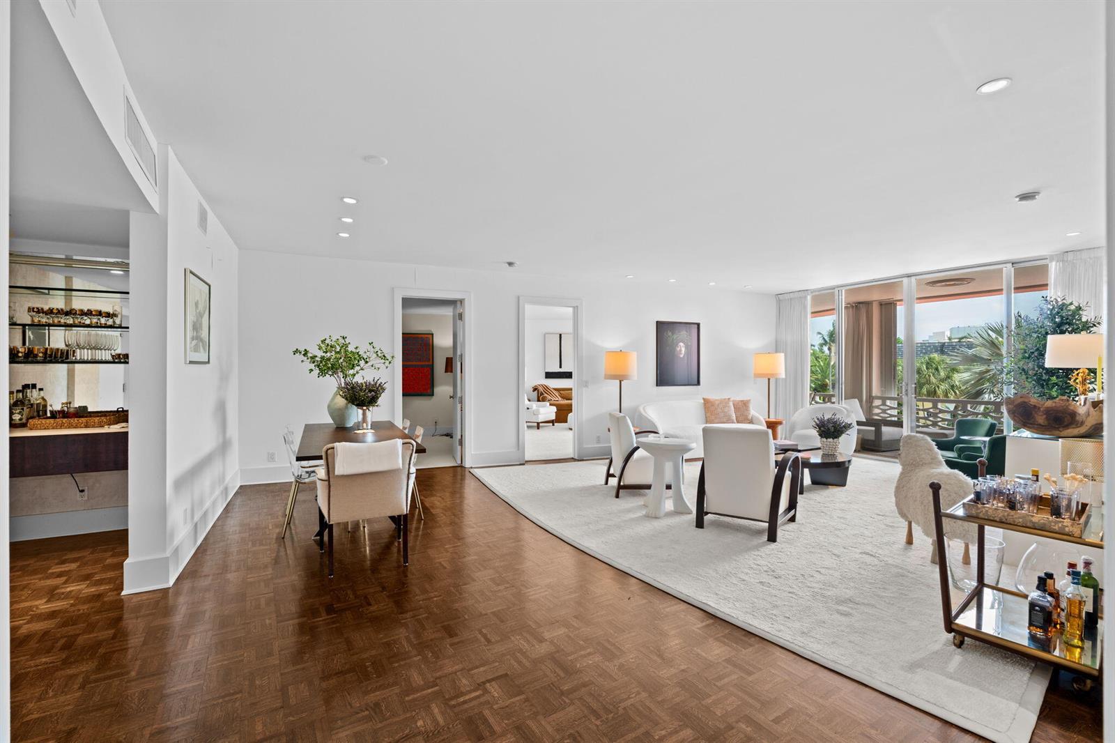 A bright, open-concept living and dining area features hardwood floors, white walls, and floor-to-ceiling windows — 315 S Lake Drive # 3d, Palm Beach FL 33480, PALM BEACH, FL